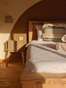 a bedroom with a bed and a nightstand next to it at DESERT Ezuz in ‘Ezuz