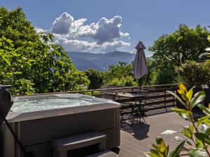 a hot tub on a deck with a table and an umbrella at Mountain View Suites in Tesimo