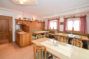 a dining room with wooden tables and chairs at Ferienhof Wölflbauer in Saalbach-Hinterglemm