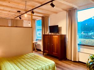 ein Schlafzimmer mit einem Bett und einem großen Fenster in der Unterkunft primiero-suite 45mq in Transacqua