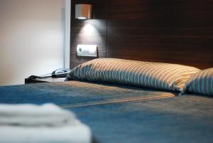 a hotel room with a bed with a wooden headboard at Hotel Porto Calpe in Calpe