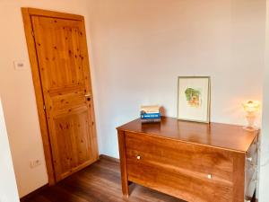 ein Zimmer mit einer Holzkommode und einer Tür in der Unterkunft primiero-suite 45mq in Transacqua