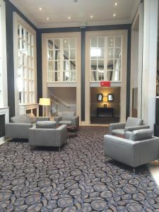 a lobby with couches and chairs and a fireplace at Park Inn by Radisson Shannon Airport in Shannon