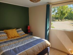 una camera da letto con un letto e una grande finestra di Gîte et Chambre d'hôte de l'élevage du Lattay a Châteauneuf-sur-Sarthe