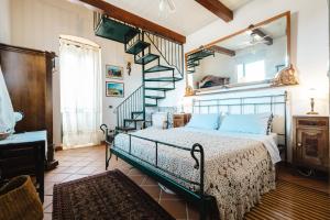 a bedroom with a bed and a spiral staircase at Tenuta Rasocolmo in Messina