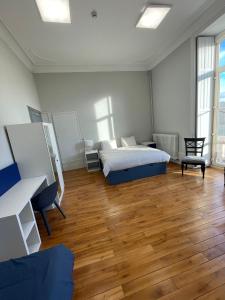 ein Schlafzimmer mit einem Bett und einem Holzboden in der Unterkunft Château de Savonnières in La Bruère-sur-Loir