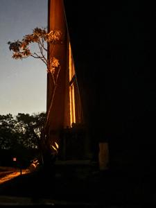a tower with a tree in front of a building at O Canto das Fadas Chalés in São Thomé das Letras
