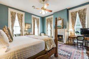 1 dormitorio con paredes azules, 1 cama y TV en Noble Inns, en San Antonio