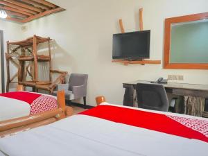 een slaapkamer met een bed, een bureau en een televisie bij 900 Inn in Bintulu