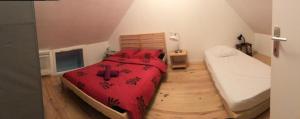 ein Schlafzimmer mit einem großen Bett mit einer roten Decke in der Unterkunft La p'tite maison in Montalieu-Vercieu