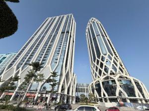 two tall buildings with cars parked in front of them at QNC Taiyo Homestay in Hai Phong