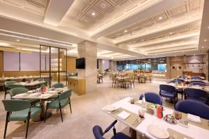 帕坦科特Riviera Sarovar Portico Pathankot的有桌椅和电视的餐厅