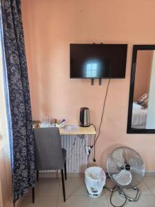 a room with a desk with a television on the wall at Dulelo Serowe in Serowe +28 photos