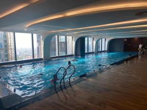 a large swimming pool with people in the water at QNC Taiyo Homestay in Hai Phong