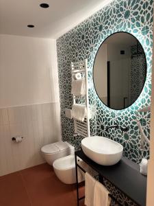 a bathroom with a sink and a mirror and a toilet at Hotel Sole in Maiori