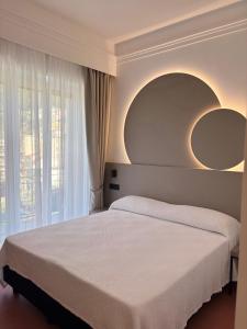 a bedroom with a bed with two mirrors on the wall at Hotel Sole in Maiori