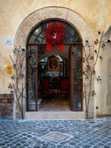 une entrée voûtée avec une couronne sur la porte dans l'établissement Locanda Sibilla Luxury Suites, à Tivoli
