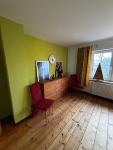 een woonkamer met 2 stoelen en een houten vloer bij Auszeit bei Katharina in Frauenstein