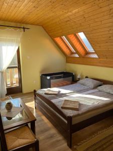 een slaapkamer met 2 bedden en een plafond met dakramen bij Pensiunea Jazmin in Zetea