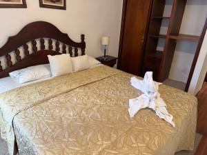 ein Schlafzimmer mit einem Bett mit einer weißen Schleife darauf in der Unterkunft NOVA Hotel Pinamar in Pinamar + 10 Fotos