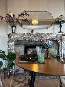a dining room with a table and a fireplace at Aux étangs fleuris in Rochefort
