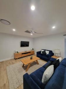 a living room with a blue couch and a table at Sheik Oasis in Lightning Ridge