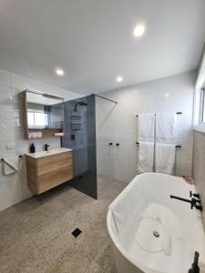 a white bathroom with a tub and a sink at Sheik Oasis in Lightning Ridge +14 photos
