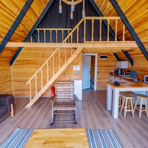 a large room with a staircase in a log cabin at Bugi Suit Bungalov in Erenköy