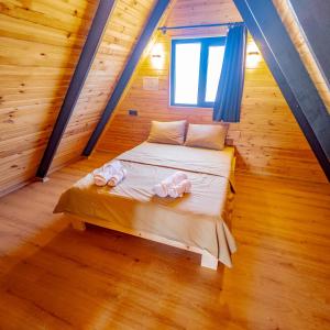 a bed in a wooden room with a window at Bugi Suit Bungalov in Erenköy