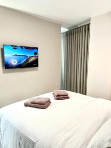 een slaapkamer met een bed en een tv aan de muur bij Iris Apartment II Livadeia in Levádeia