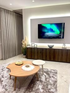 un soggiorno con TV e tavolino da caffè di Iris Apartment II Livadeia a Levádeia