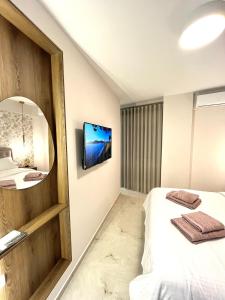 una stanza d'albergo con un letto e uno specchio di Iris Apartment II Livadeia a Levádeia