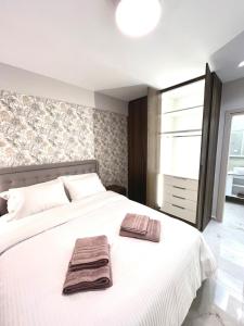 una camera da letto con un letto bianco con due asciugamani sopra di Iris Apartment II Livadeia a Levádeia