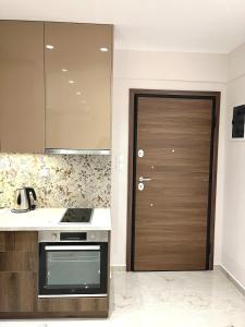 una cucina con porta in legno e piano cottura di Iris Apartment II Livadeia a Levádeia