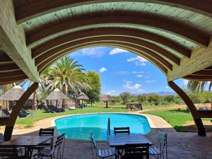 a view of a swimming pool with tables and chairs at Auas Safari Lodge in Windhoek