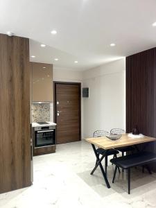 een keuken en eetkamer met een tafel en stoelen bij Iris Apartment II Livadeia in Levádeia