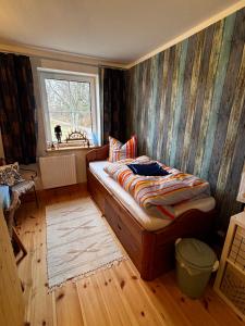 een slaapkamer met een bed met een gestreepte muur bij Auszeit bei Katharina in Frauenstein