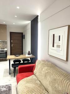 een woonkamer met een rode bank en een tafel bij Iris Apartment II Livadeia in Levádeia +11 foto's
