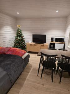 a living room with a christmas tree and a table at Arctic Sauna Cabin in Rovaniemi