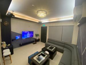 ein Wohnzimmer mit Sofa und Fernseher in der Unterkunft Fun B&B in Altstadt von Hengchun
