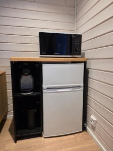 a microwave sitting on top of a refrigerator at Arctic Sauna Cabin in Rovaniemi +7 photos