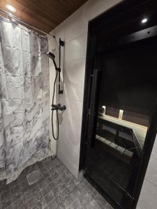 a shower in a bathroom with a shower curtain at Arctic Sauna Cabin in Rovaniemi