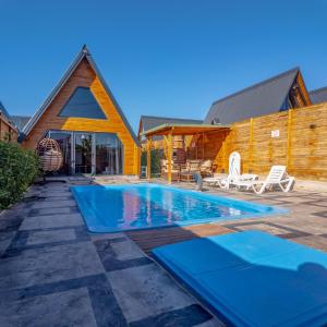 a swimming pool in front of a house at Bugi Suit Bungalov in Erenköy