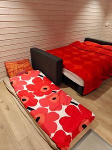 a bedroom with a bed with a red and white comforter at Arctic Sauna Cabin in Rovaniemi