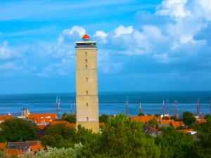 a tall building with a lighthouse in a city at Huisje Stockholm op Terschelling in West-Terschelling