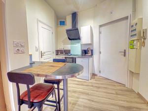 une petite cuisine avec une table et deux chaises dans l'établissement Beau Studio Neuf proche du centre et de Nausicaa, à Boulogne-sur-Mer