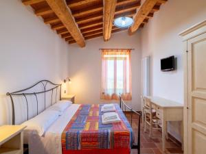 a bedroom with a bed and a desk and a window at Apartment in a farmhouse with 2 swimming pools in Cagli +126 photos