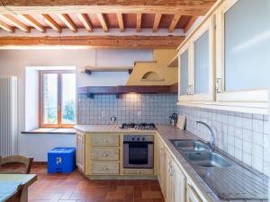 a kitchen with a sink and a stove at Apartment in a farmhouse with 2 swimming pools in Cagli