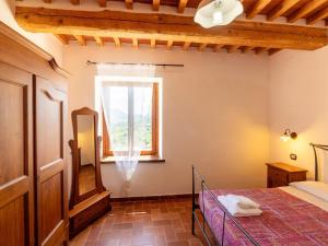 a bedroom with a bed and a window at Apartment in a farmhouse with 2 swimming pools in Cagli