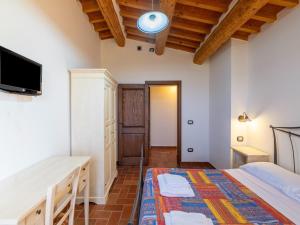 a bedroom with two beds and a flat screen tv at Apartment in a farmhouse with 2 swimming pools in Cagli